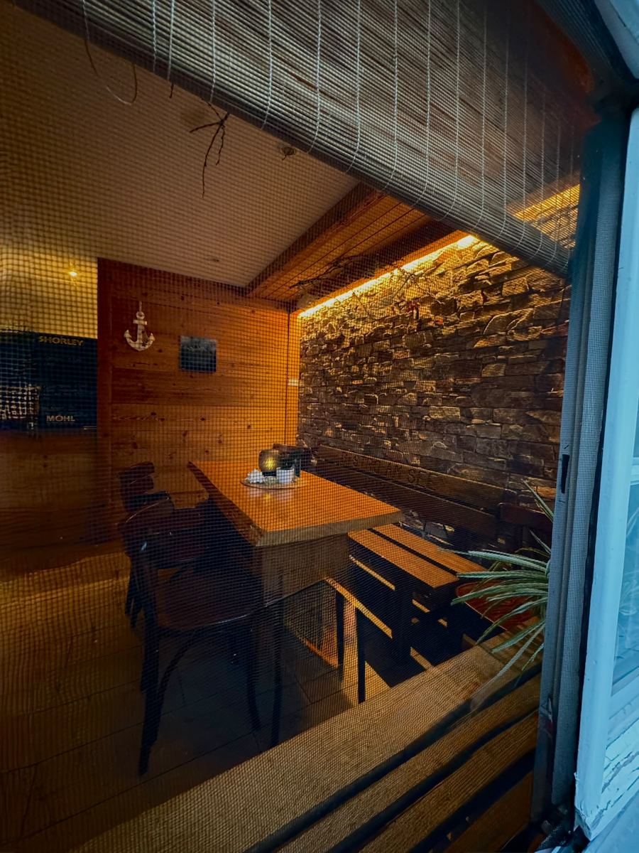 Blick durchs Fenster ins abendlich beleuchtete Bistro