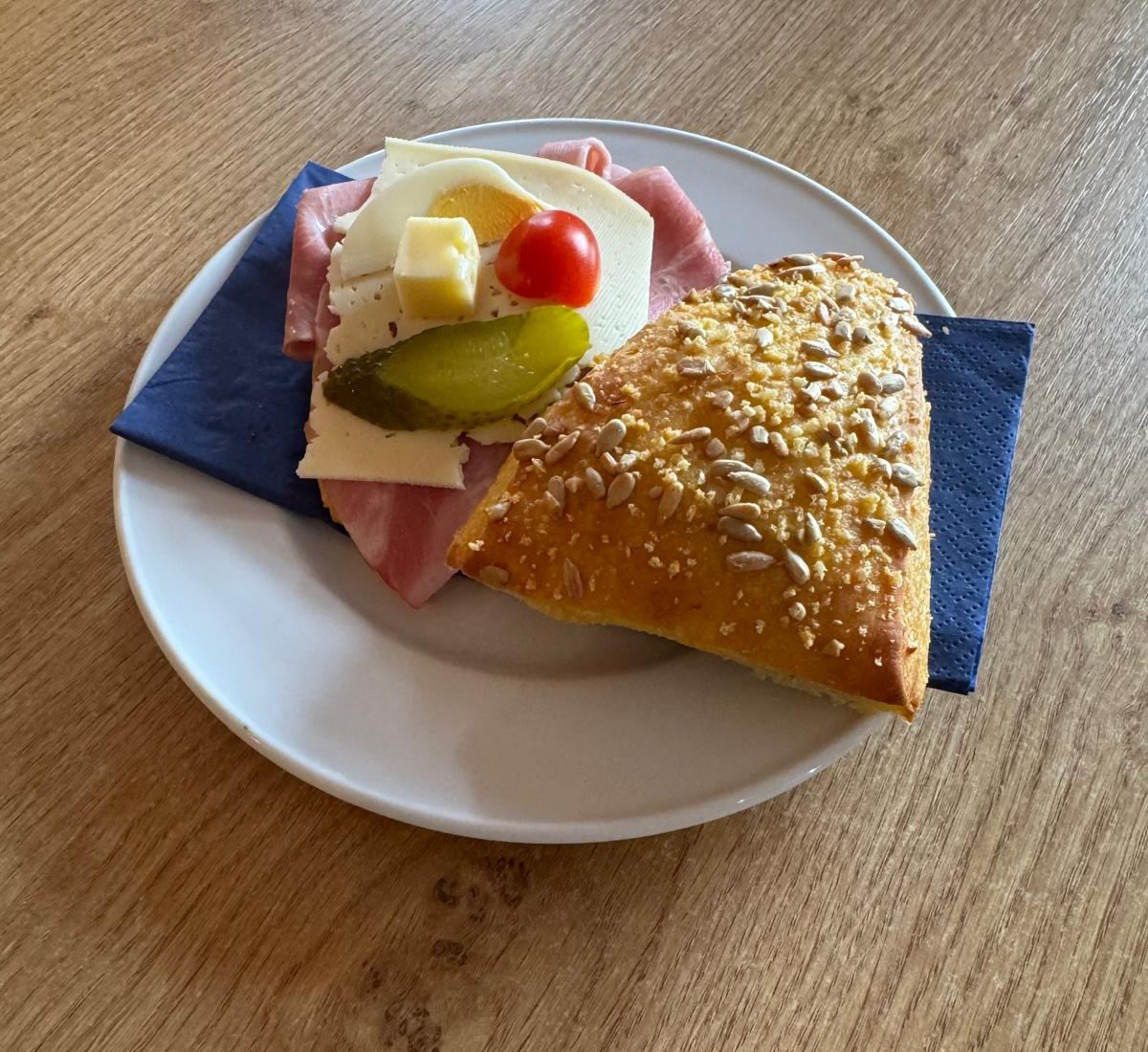 Sandwich mit Schinken, Käse, Ei, Tomate und Gürkli im Sonnenblumen-Brötli